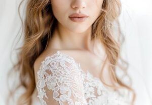 Gros plan sur les manches en dentelle d’une robe de mariée avec effet illusion chez White Boutik Paris