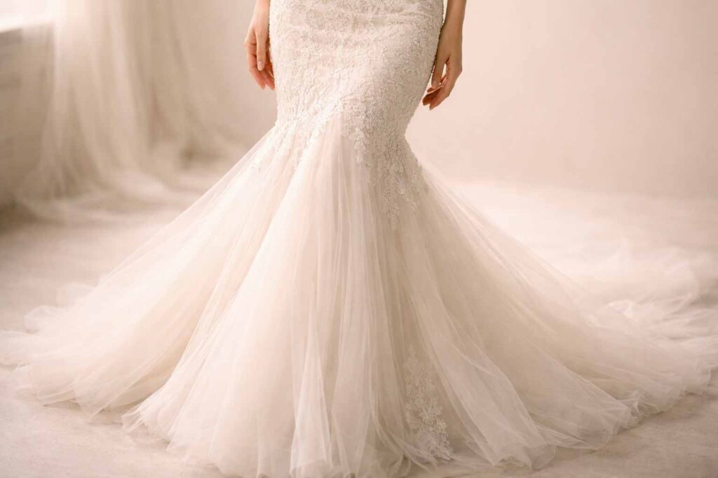 Point d’évasement d’une robe de mariée sirène visible à mi-cuisse